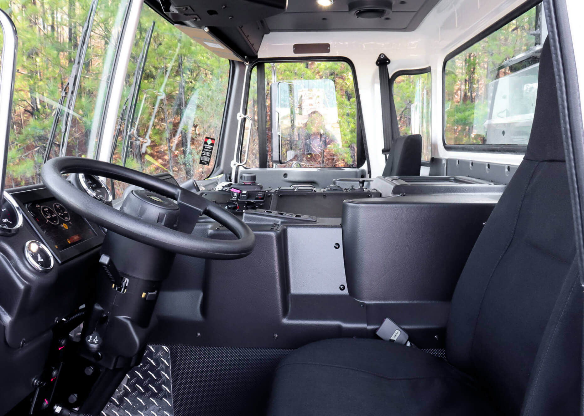 Interior view of the Autocar ACX side loader showing driver’s seat and control panel. 