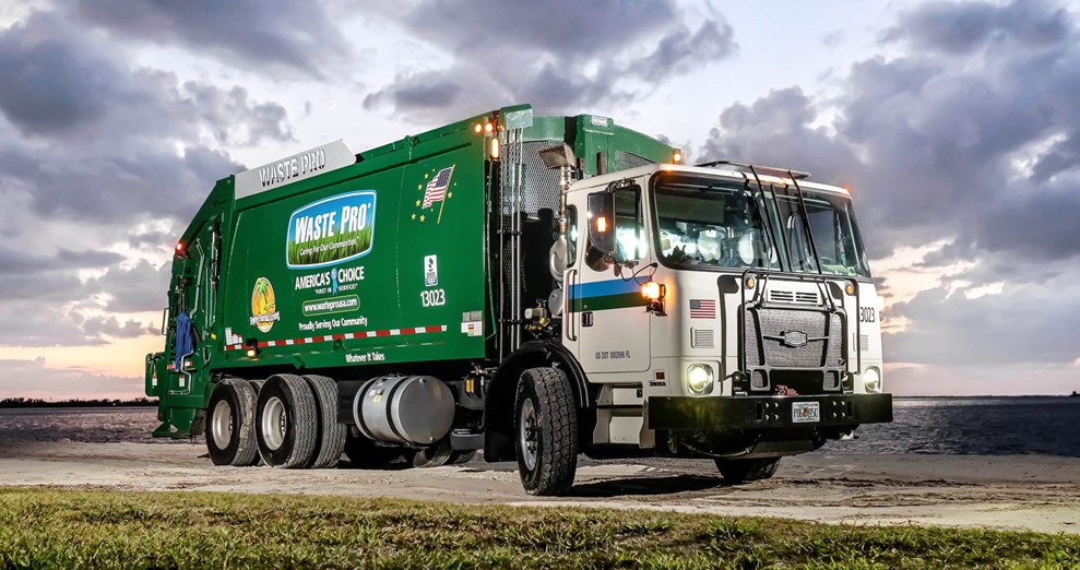 The Autocar severe duty ACX rear-end loader trash truck, parked by the water’s edge